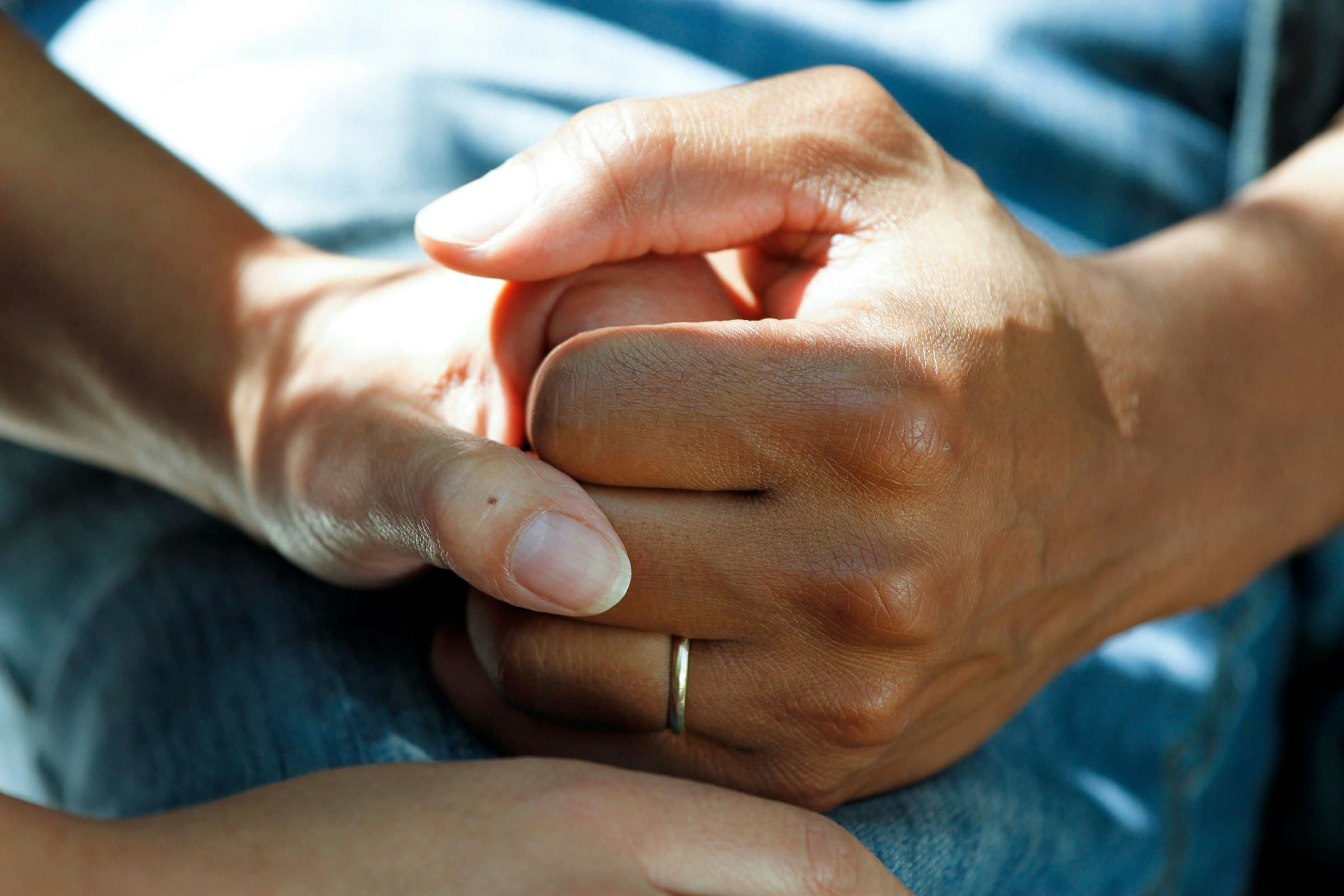 A caregiver holding a patient's hand